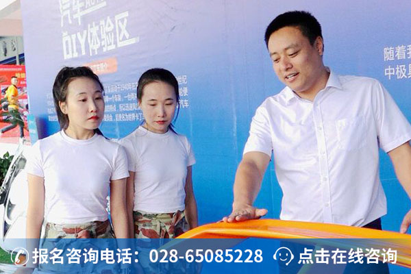 双胎姐妹花在学校袁主任带领下，参观学生自己动手改装的汽车。